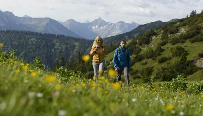 Wanderer überqueren eine Blumenwiese