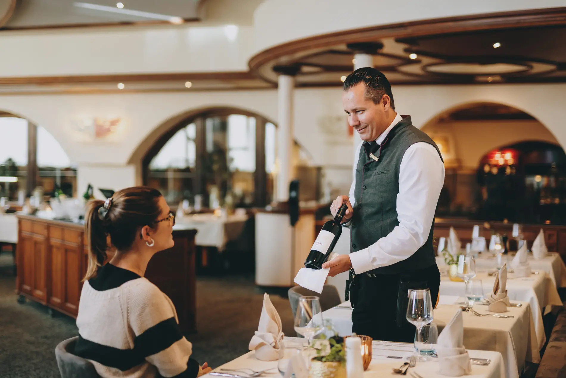 Sommelier präsentiert eine Falsche Wein einer Kundin im Restaurant.