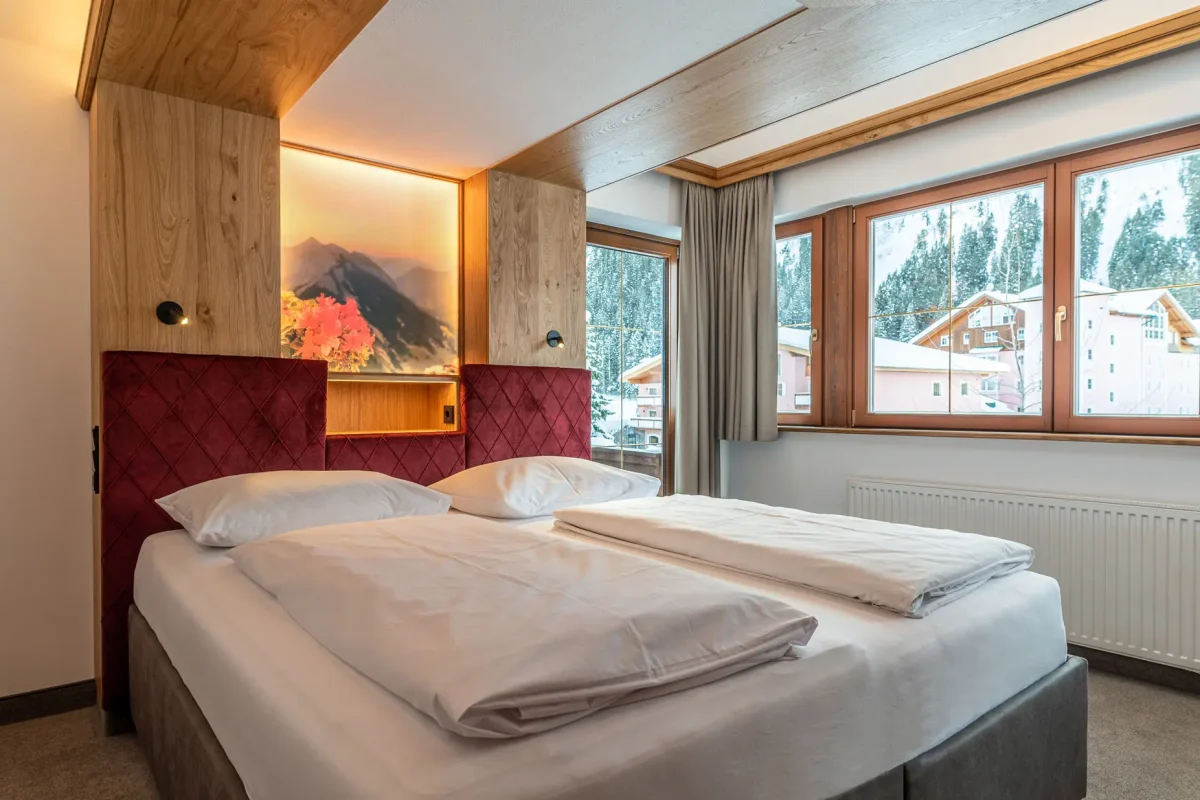 Doppelbett mit Ausblick im Zimmer Alpenrose